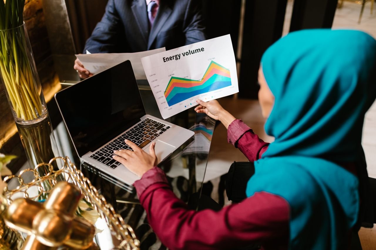 Muslim woman analyzing energy volume data during a business meeting.